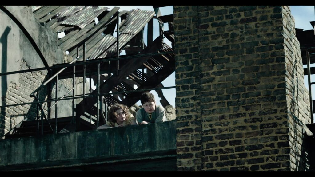 Digory en Polly kijken vanaf een vervallen gebouw naar beneden in de trailer van Narnia