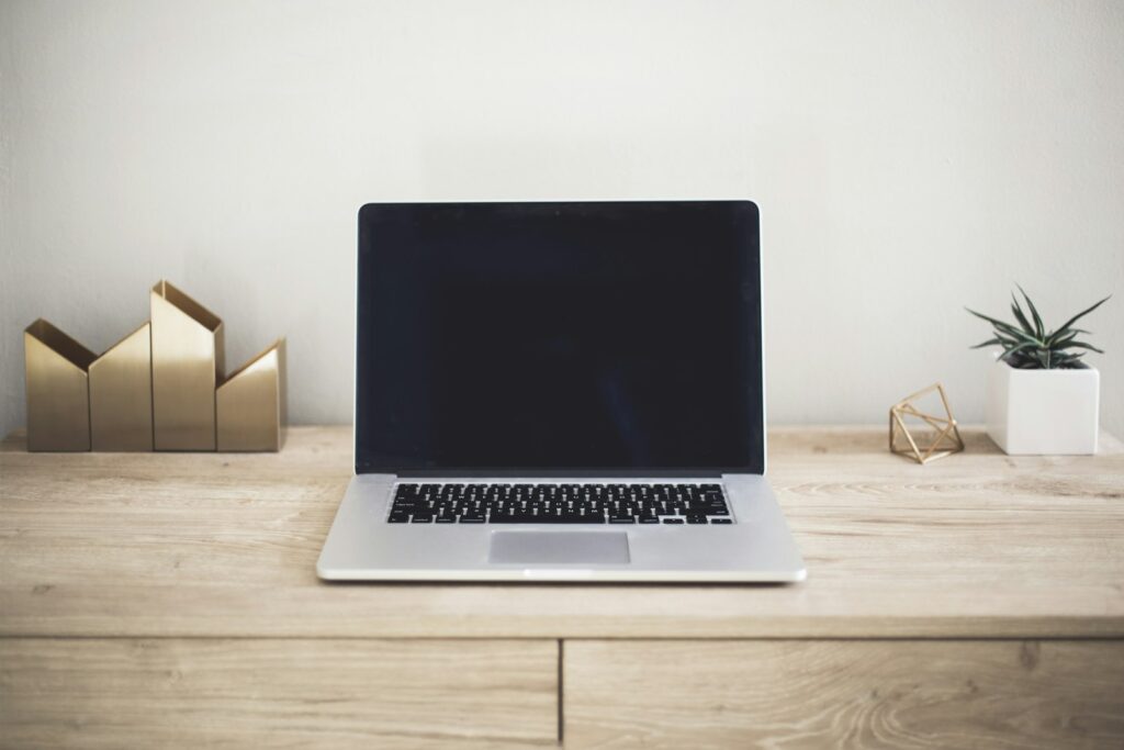 Laptop met een e-bookbibliotheek naast een e-reader op een bureau