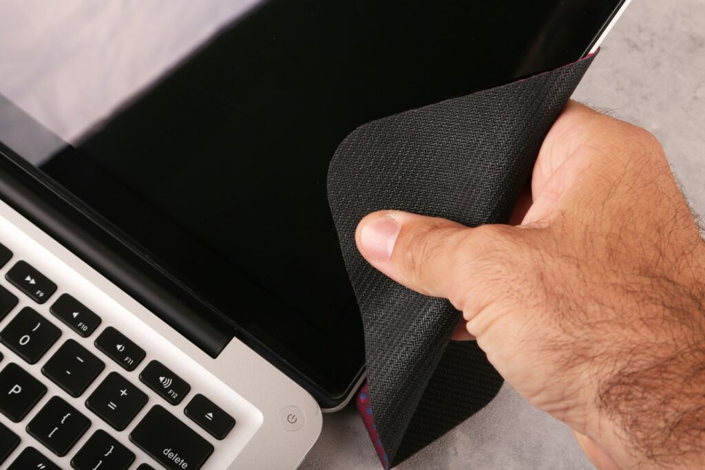 Iemand veegt het scherm van een e-reader schoon met een microvezeldoek