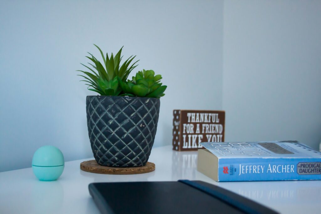 E-reader met een geopend boek naast een laptop op een houten bureau