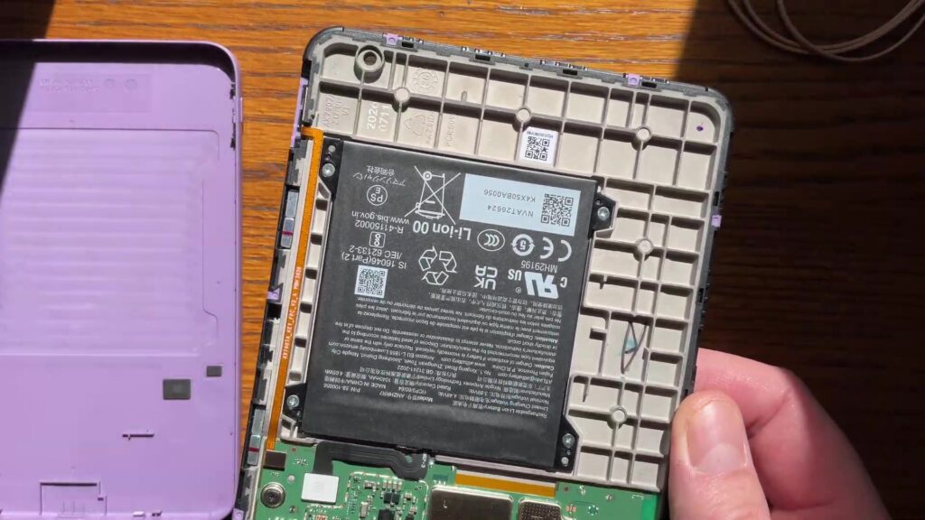 Geopende Kindle 2026 met losse paarse achterkant en zichtbare batterij