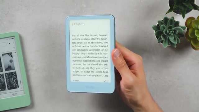 Hand houdt de nieuwe Kindle 2026 met een geopend boek op het scherm