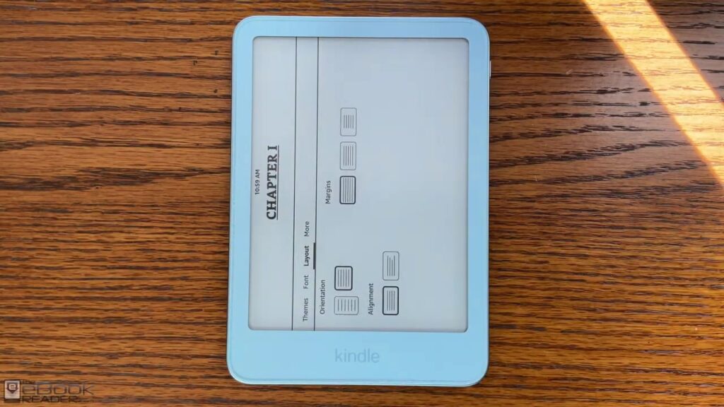 De Kindle Aluminum in de kleur Alpine Sky op een houten tafel met het leesmenu open