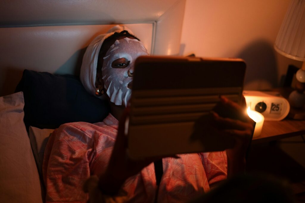 E-reader met verlichting in een donkere slaapkamer naast een bedlampje