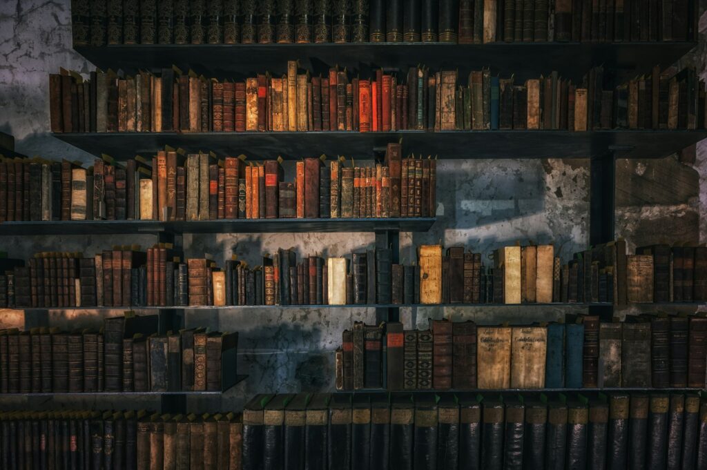 Oude boeken en een leeslamp naast een houten kast