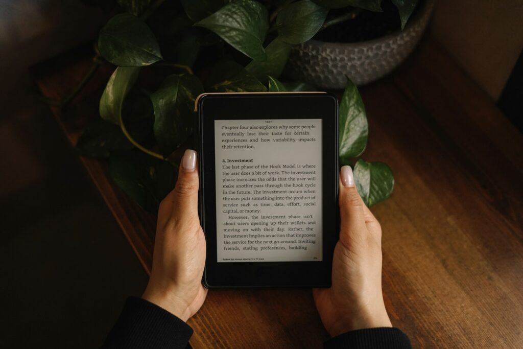 E-reader op een stapel boeken met herfstbladeren